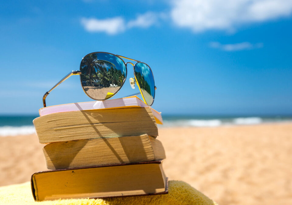 Books and sunglasses on the beach summer reading